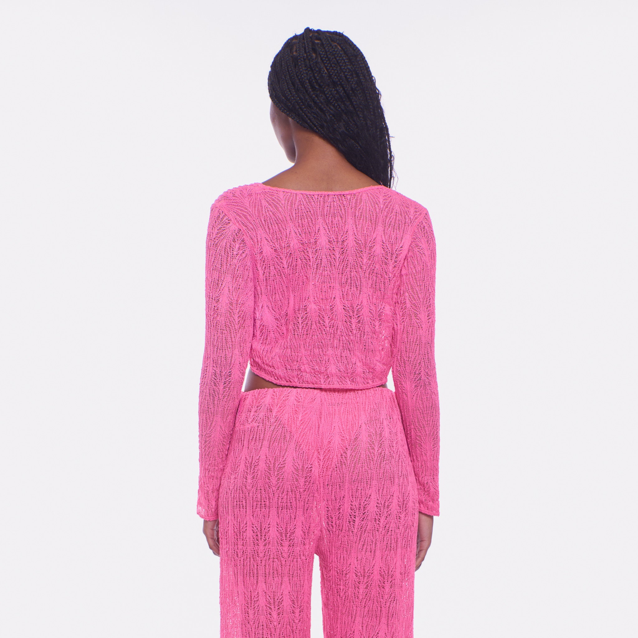 Person wearing a bright pink textured outfit on a white background