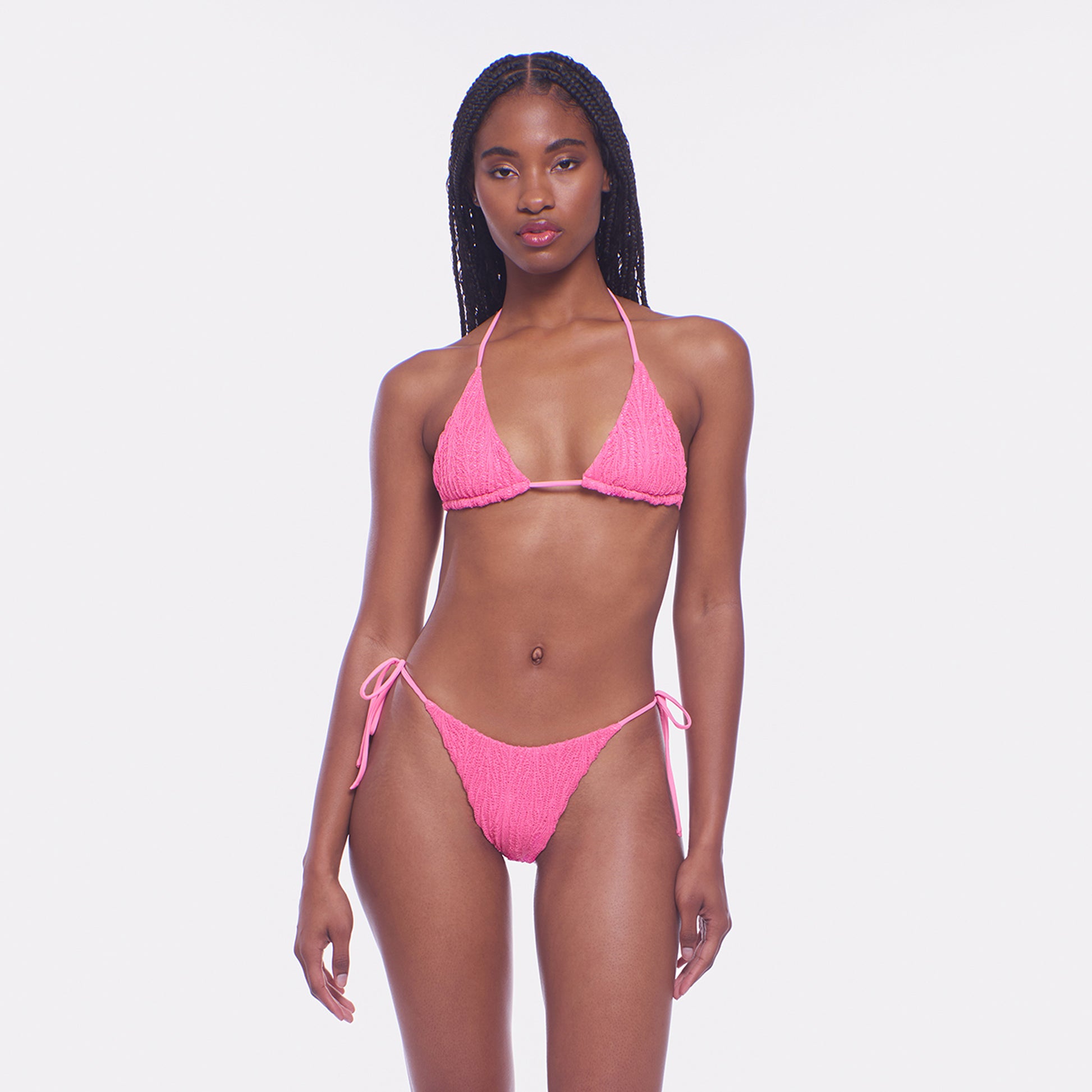 Woman wearing a pink bikini against a white background