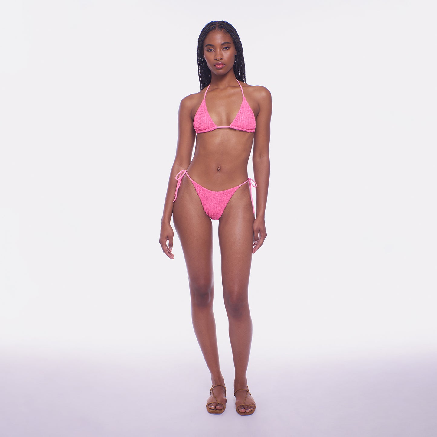 Woman wearing a pink bikini on a white background