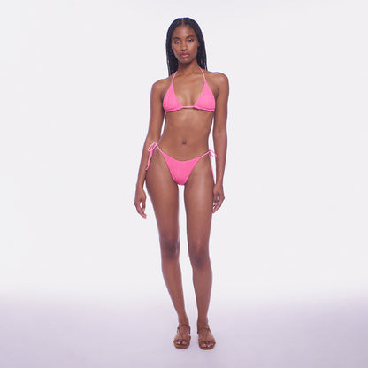 Woman wearing a pink bikini on a white background