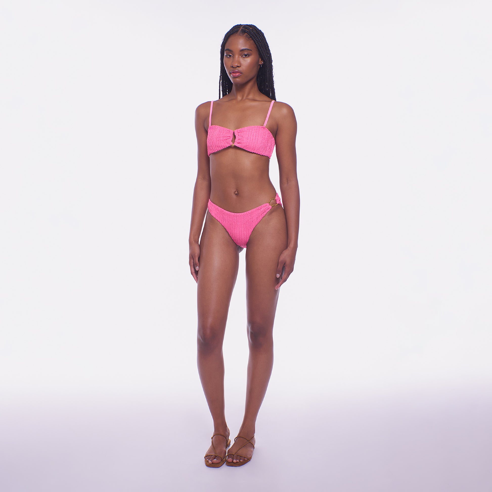 Model wearing a pink bikini set on a white background