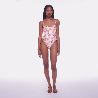 Woman wearing a floral one-piece swimsuit on a white background