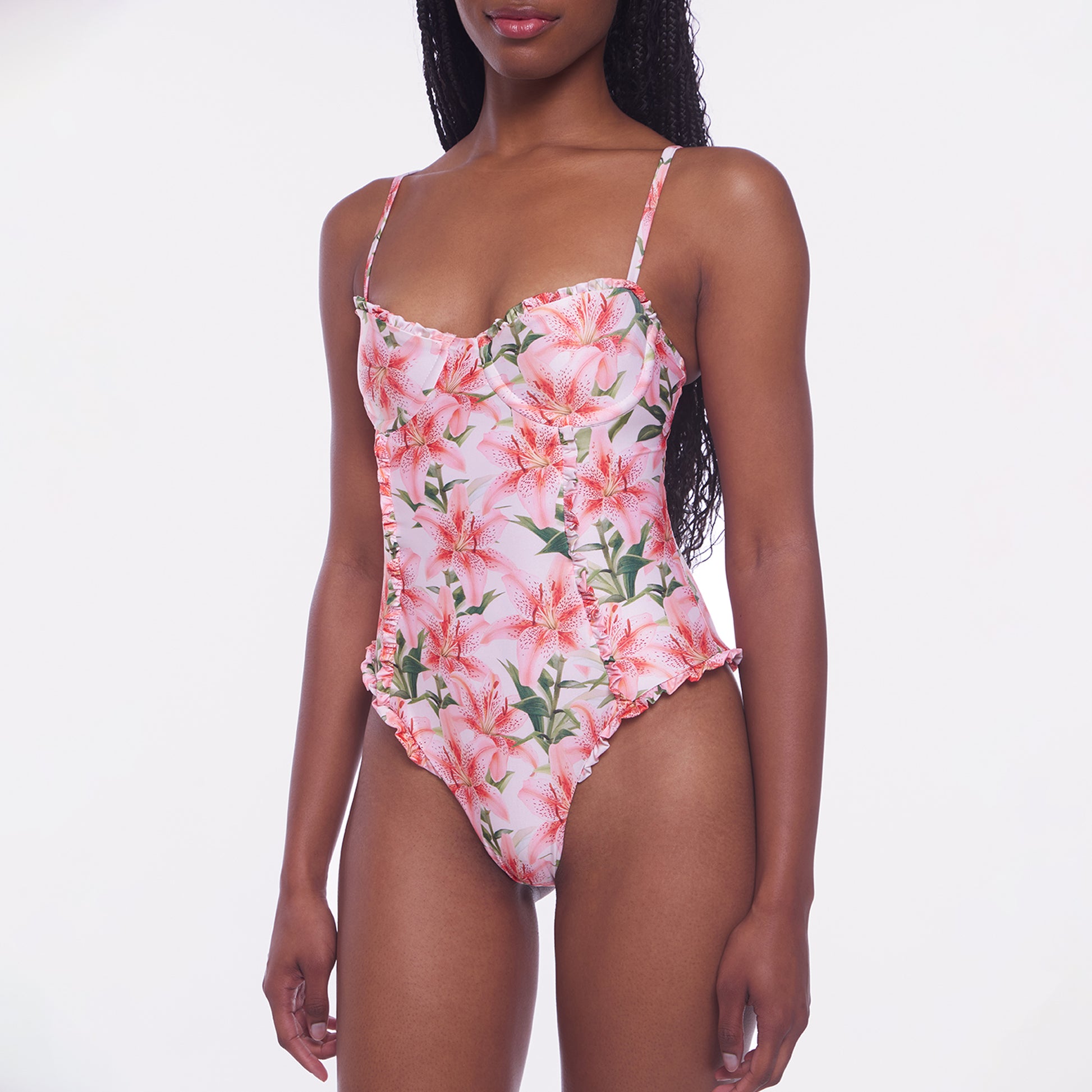 Woman wearing a floral one-piece swimsuit on a white background