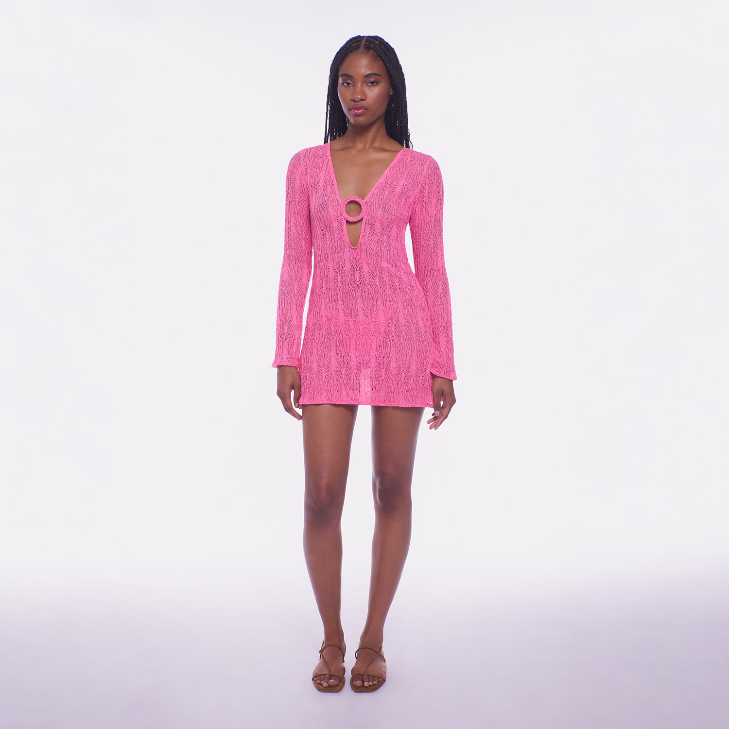 Woman wearing a pink dress with long sleeves on a white background