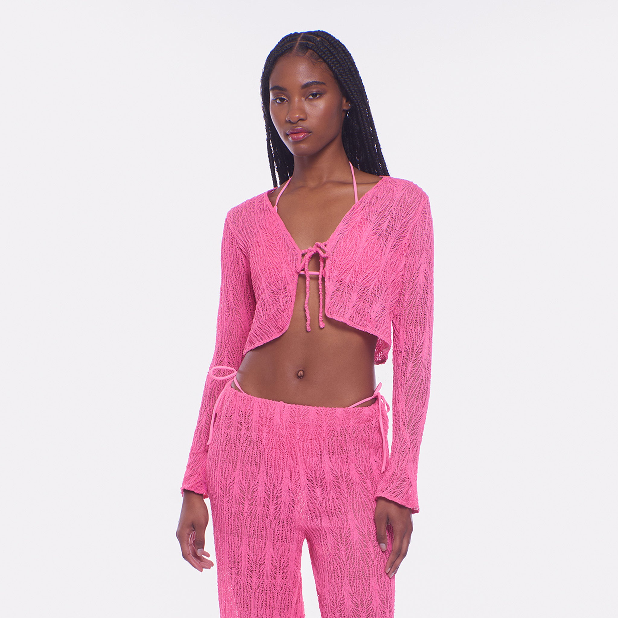 Woman wearing a pink textured outfit on a white background