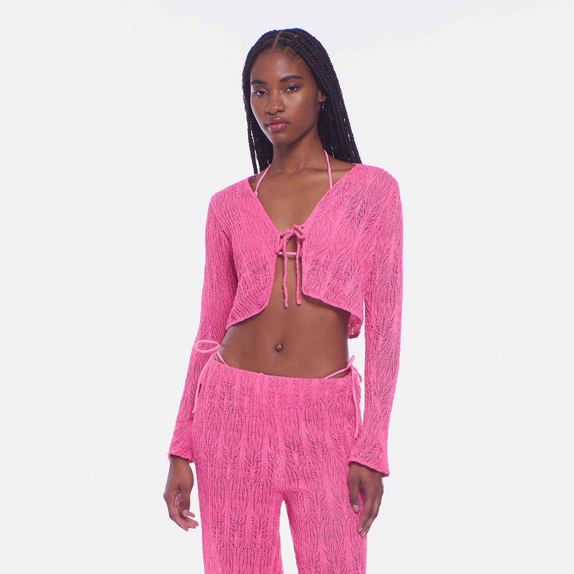 Woman wearing a pink textured outfit on a white background