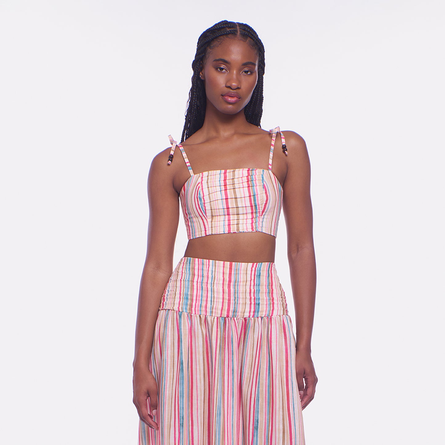 Woman wearing a colorful striped dress on a white background