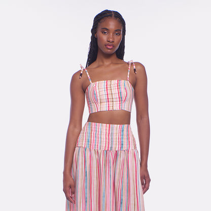 Woman wearing a colorful striped dress on a white background