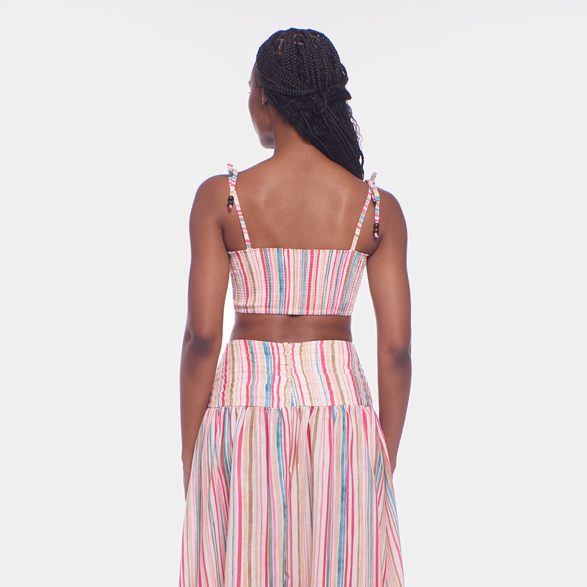 Woman wearing a colorful striped dress on a white background