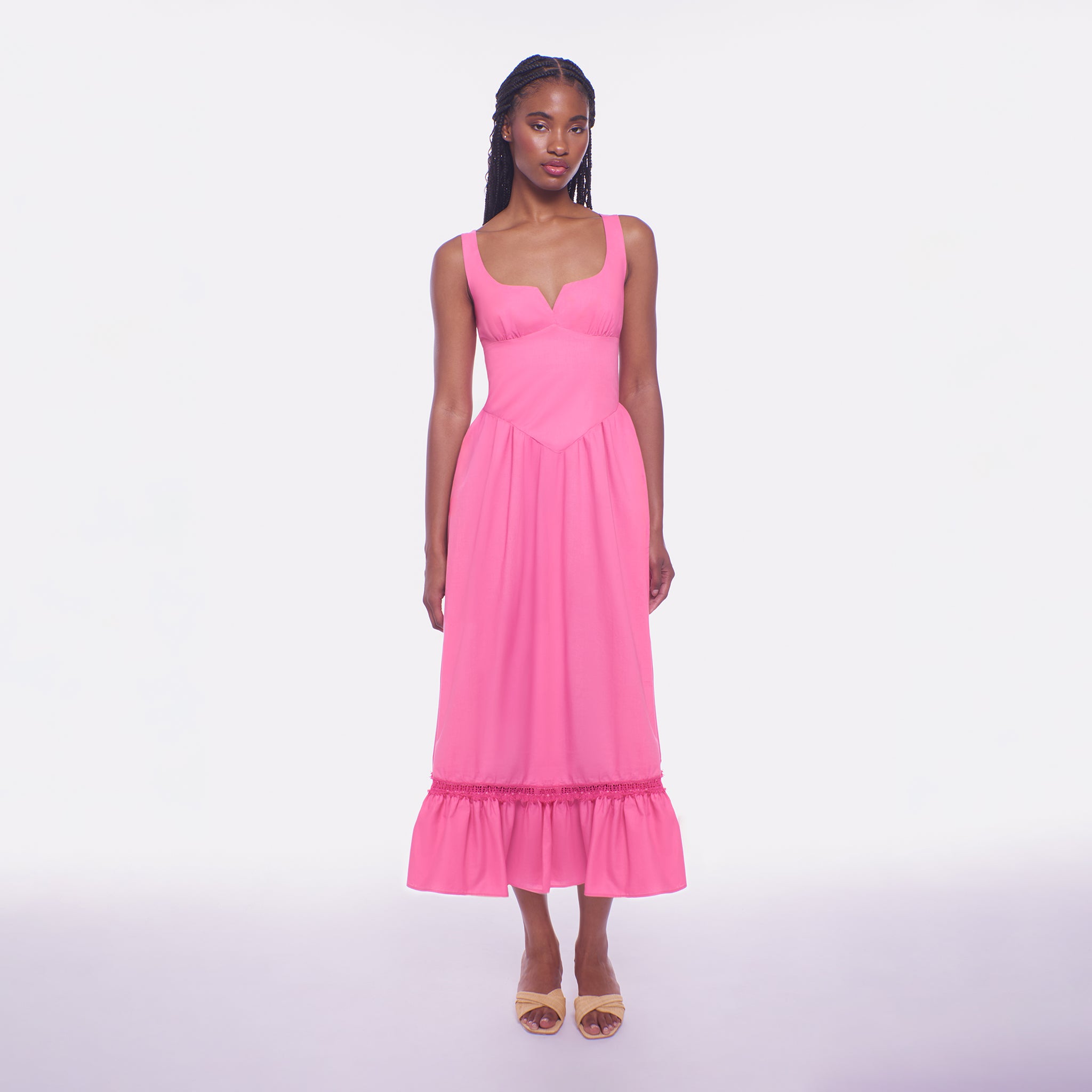 Woman wearing a pink midi dress on a white background