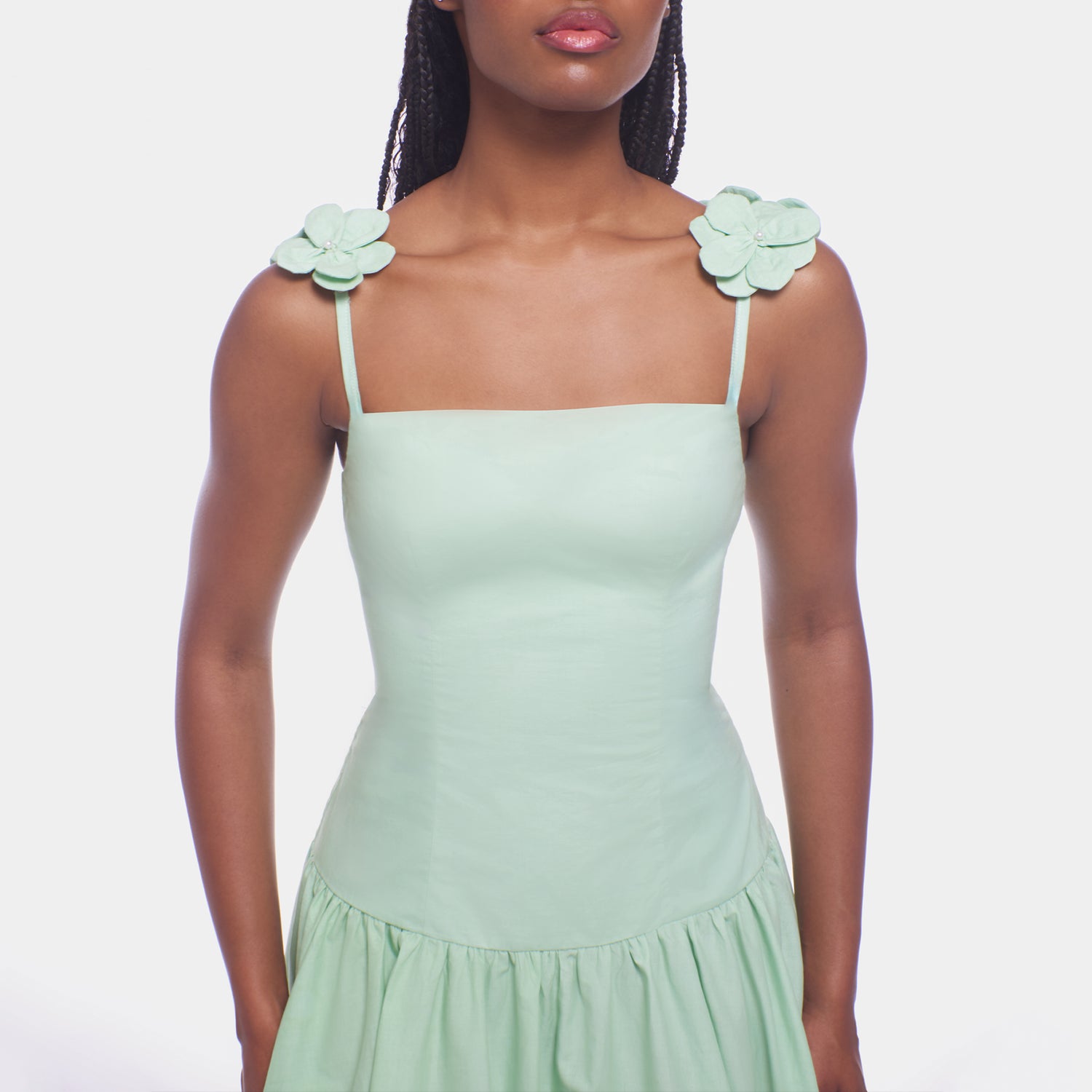 Light green dress with floral shoulder details on a plain background