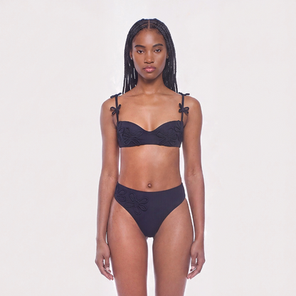 Woman wearing a black bikini set on a white background
